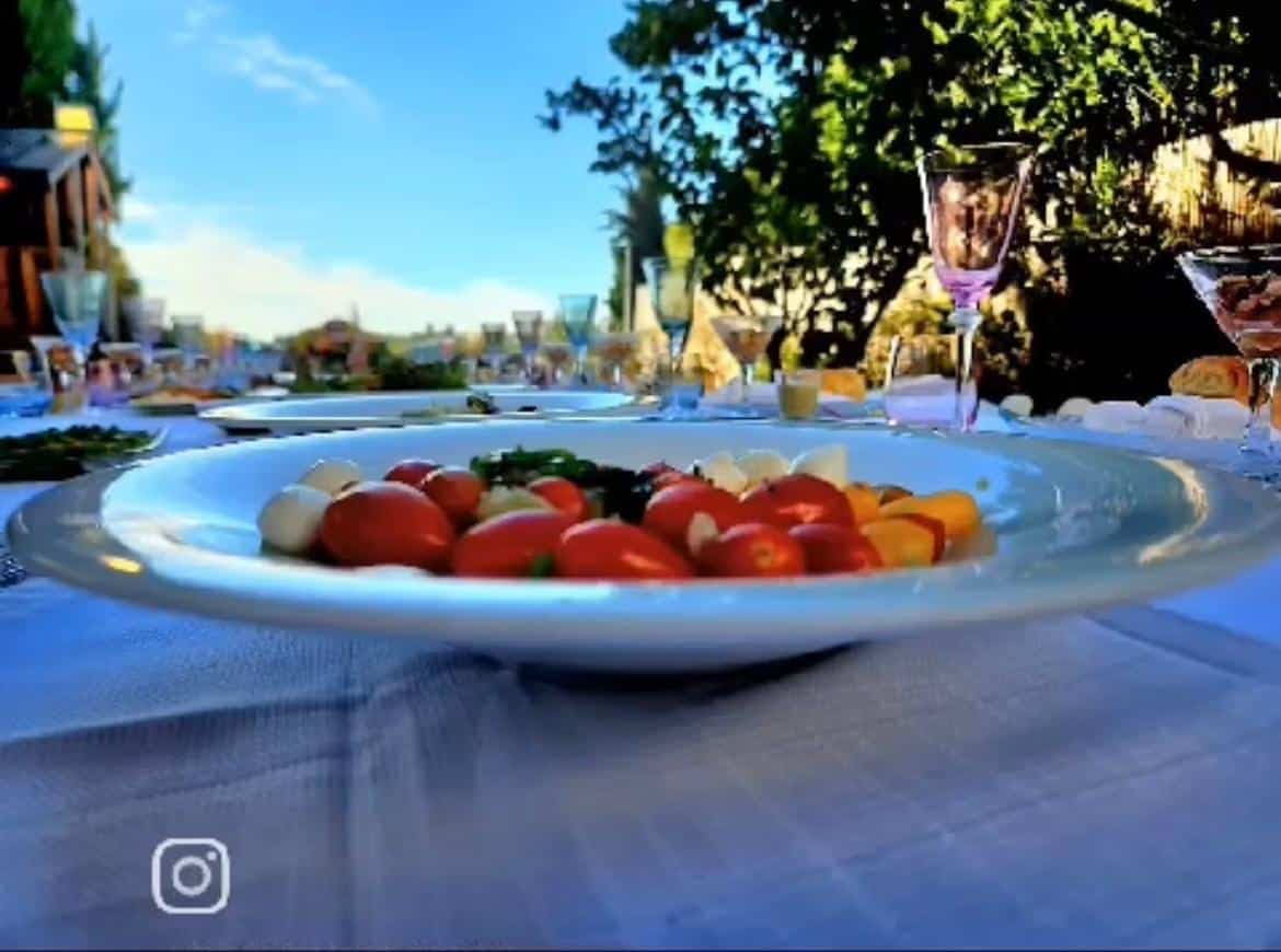 שולחן ערוך לאירוע עם צלחות אוכל צבעוניות וכוסות יפות, עיצוב מושלם לאירועים.