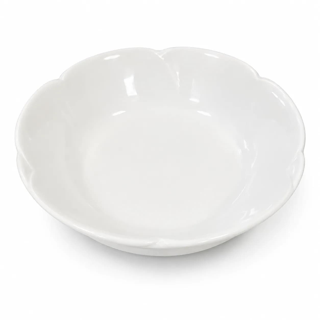 קערה ריקה ליד תפוזים ופרחים על שולחן